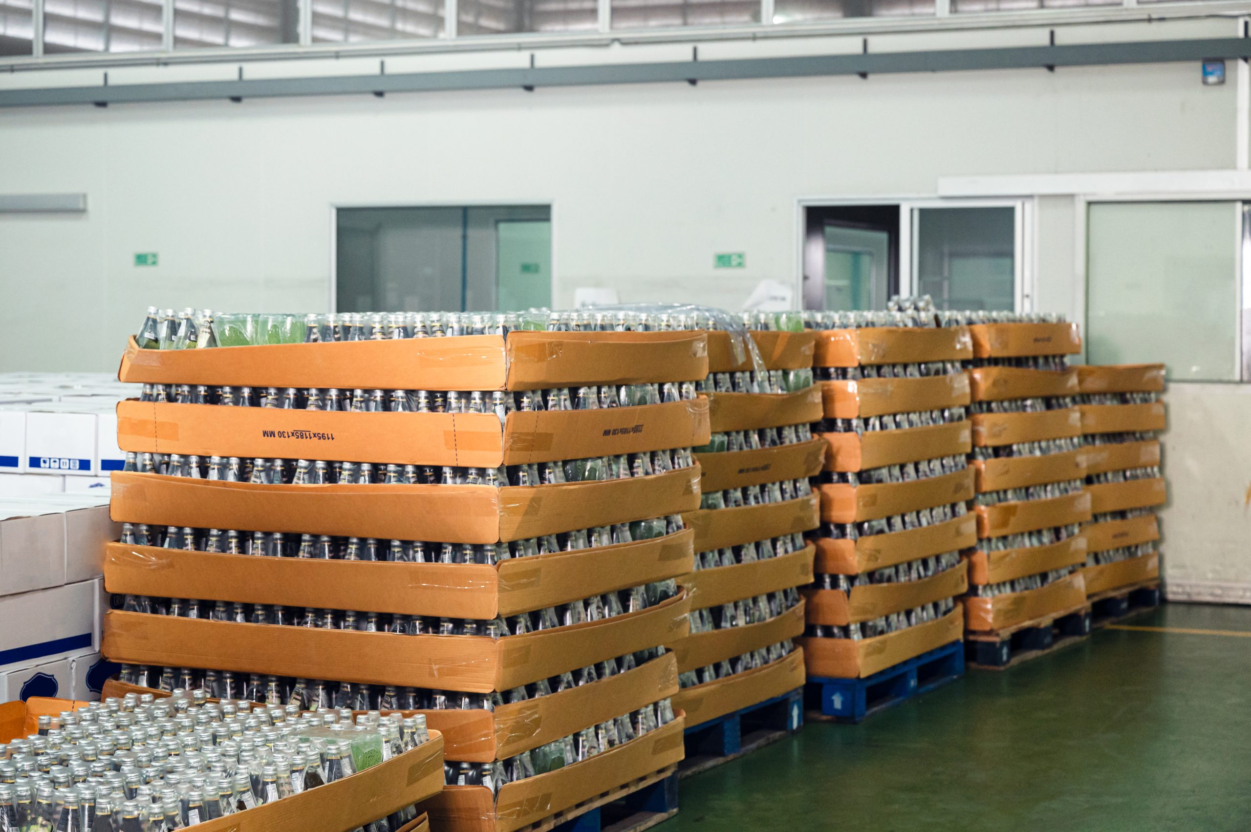 Pallets with glass bottles in warehouse